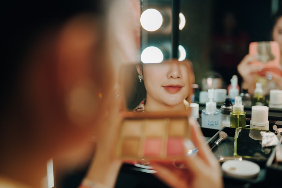 Klijentica salona Rumenilo ispred ogledala s vanity lampama
